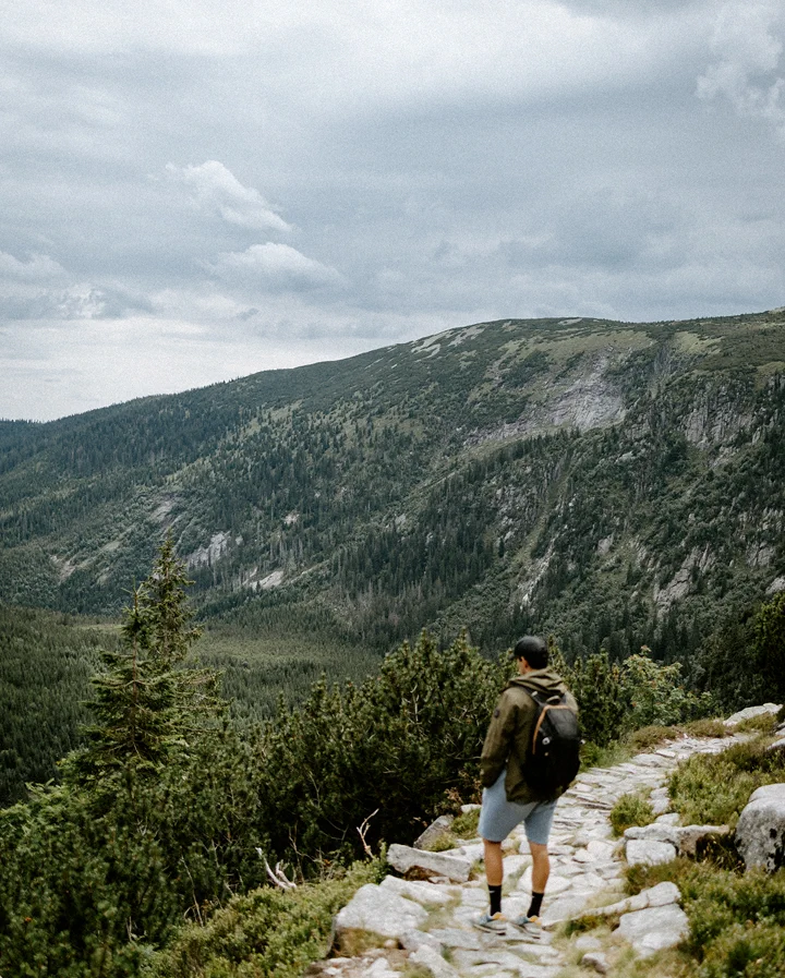 Muž stojící na skále a hledící do krajiny